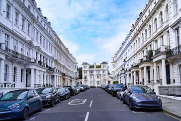 Fototapeta premium Street with long row of elegant white townhouses in the London Borough of Kensington