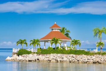 A Gazebo near an ocean with blue water and rocks