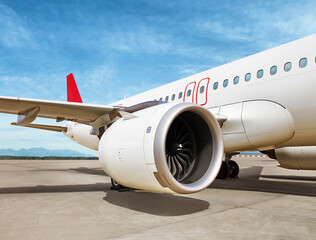 Detailed view of a commercial aircraft jet engine and wing on the runway at the airport. Modern...