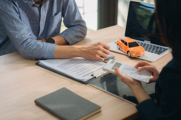 Auto Loan Consultation:  A close-up shot of a financial advisor and client reviewing car loan...