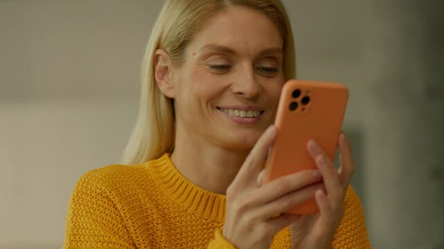 Close up smiling woman hold use smartphone sitting at home. Scrolling social media. Camera moving around. 360 degrees