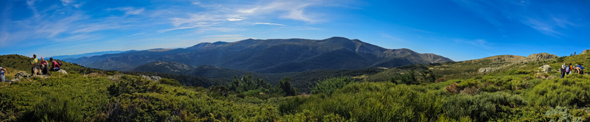 Obraz premium The path to the summit of Peñalara reveals stunning vistas of the surrounding mountains and lush vegetation. A hiker's paradise.