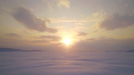 Fototapeta premium Sunset over a snow-covered landscape with a hint of pink in the sky