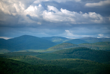 Clouds over the hills covered with forest