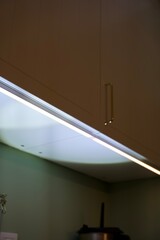 close up of a door of kitchen cabinet with led light underneath
