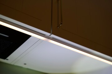 close up of a door of kitchen cabinet with led light underneath