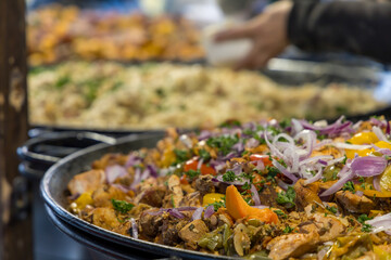 Street food. Grilled meat and side dish on a large pan for sale at the market