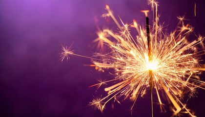 Fototapeta premium glittering burning sparkler on purple background