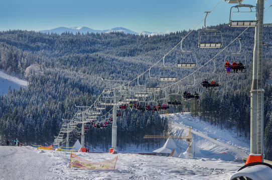 snowy landscape at a ski resort track with chairs, snowy slopes and fir trees