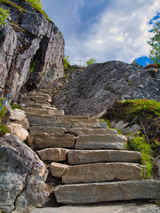 Steep stone steps on a hiking trail in northern Norway. A steel rail is set at the side of the...