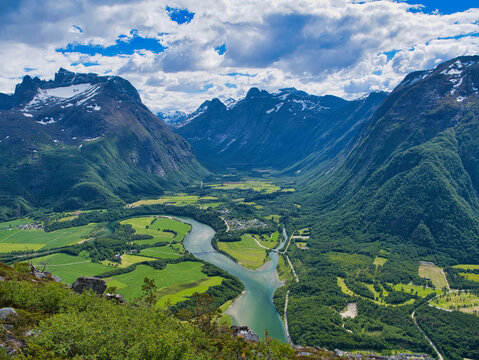 A view of the Rauma River and surrounding mountains near Andalsnes in Norway. Taken from the Rampestreken view point on a sunny day in summer with a blue sky and white clouds.