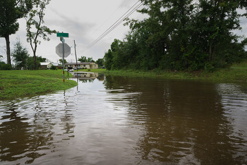 Flooded road after heavy rain, water covering the pavement and creating a challenging passage.