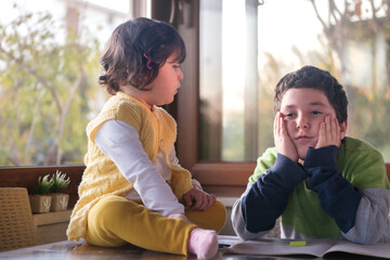 Little girl tries to play with her brother. The siblings spend time together.