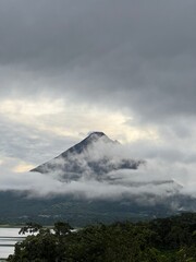 Scenic view of a towering volcano blanketed in clouds, reflecting the beauty of nature. Ideal for...