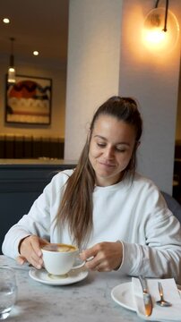 Femme qui sourie en prenant un caf&eacute;