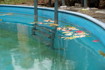 Sediments on bottom of swimming pool in autumn. Care and cleaning of water and walls of an outdoor pool.