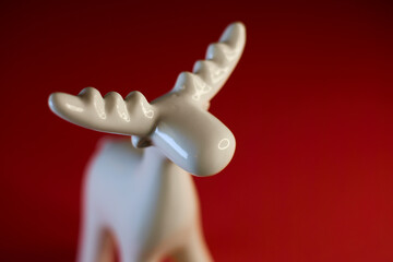 A stylized White Moose Figurine on a vibrant red background, perfect for display