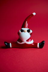 This charming and festive Santa figurine is designed in a playful pose that radiates holiday cheer