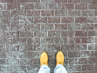 Icy sidewalk with anti-icing reagents improves traction. Winter boots stands on road with de-icing...