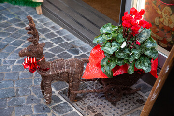 A statue of a reindeer pulling a cart full of colorful flowers