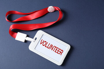 Badge with word Volunteer on dark blue background, top view