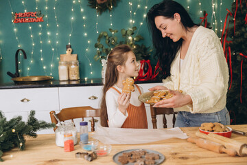 Mother and daughter baking gingerbread cookies for christmas
