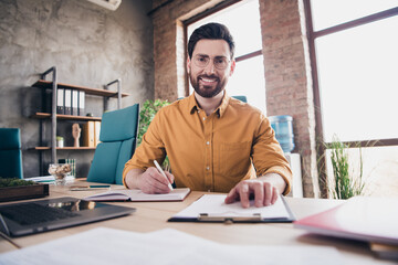Photo of attractive young man work papers wear yellow shirt formalwear comfortable modern office...