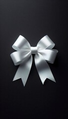 Elegant white satin ribbon bow on black background; perfect for gift wrapping, holiday cards, or special occasions