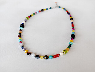 A bohemian style necklace on a whitesurface