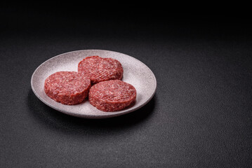Naklejka premium Fresh raw ground beef burger patty with salt and spices