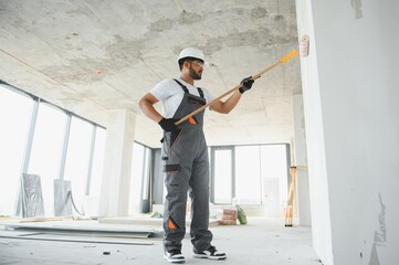 Indian Painter painting the office wall with roller paint