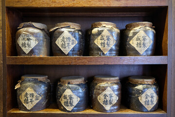 traditional chinese ceramic jars for medicine on wooden shelf