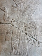 The relief engraving of the Mesopotamian winged eagle god Apkallu or Abgal graces the walls in an...