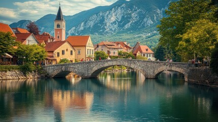 Obraz premium Picturesque Stone Bridge over Calm River, Charming Village with Mountain backdrop