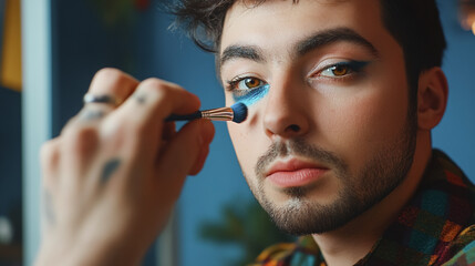 bearded man transgender applying eyeshadow with make-up brush on eye , making makeup. 