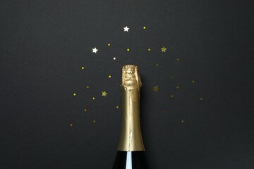 Festive background with bottle of champagne and confetti