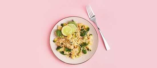 Delicious fusilli pasta with broccoli on pink background