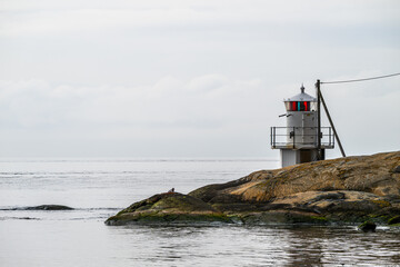 Small navigational light on a skerry at sea.