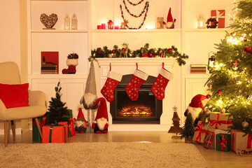 Stylish fireplace, Christmas tree with festive decor and presents indoors