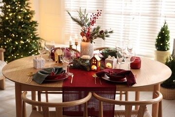 Christmas table setting with stylish dishware and festive decor indoors