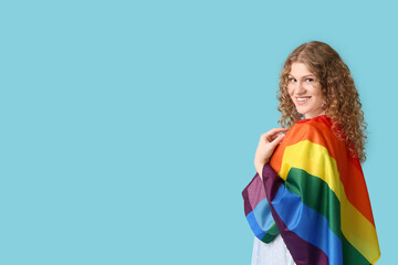 Happy young woman with LGBT flag on blue background