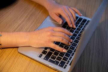 Hands are actively typing away on a laptop, whether for work purposes or for studying