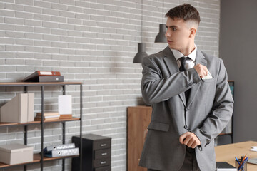 Young businessman hiding bribe into pocket in office. Corruption concept