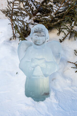 icy Christmas figure of an angel on a spruce background