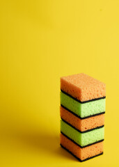 Colorful sponges on yellow backdrop