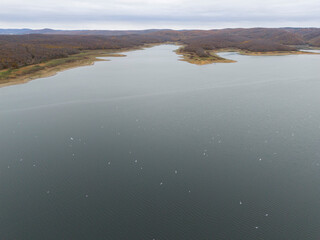 High-angle view of a serene lake with autumnal shoreline. A high-angle, full shot of a tranquil...