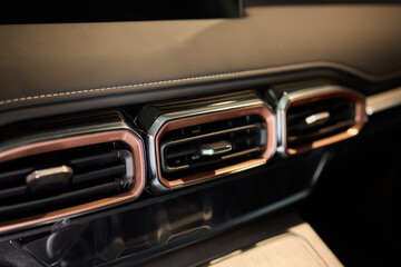 Closeup of car dashboard air vents near gear shift