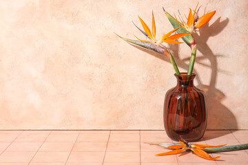 Vase with beautiful strelitzia flowers on beige tile table