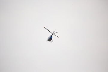 Silhouette of helicopter in blue clear sky