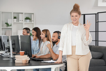 Female technical support agent showing OK in office